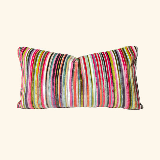 This is a rectangular decorative pillow with colorful vertical stripes. The stripes are vibrant and include shades of red, pink, green, yellow, blue, orange, black, and white, creating a lively and eye-catching design. The fabric texture appears woven, adding a tactile and cozy appearance to the pillow.