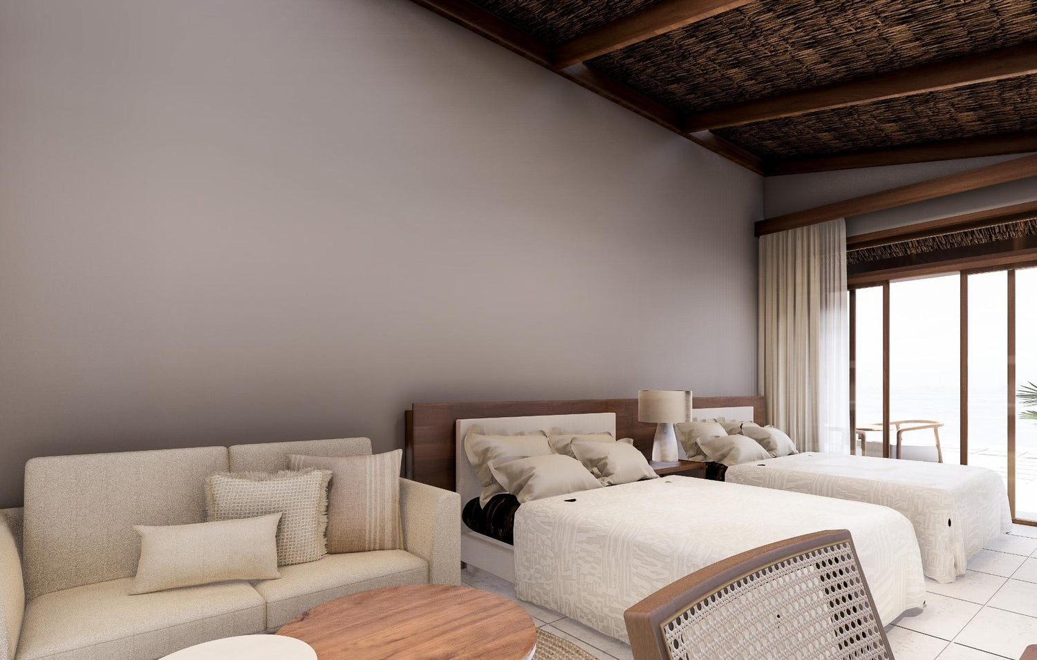 Beachside hotel room with two beds, a sofa, and a view of the ocean.