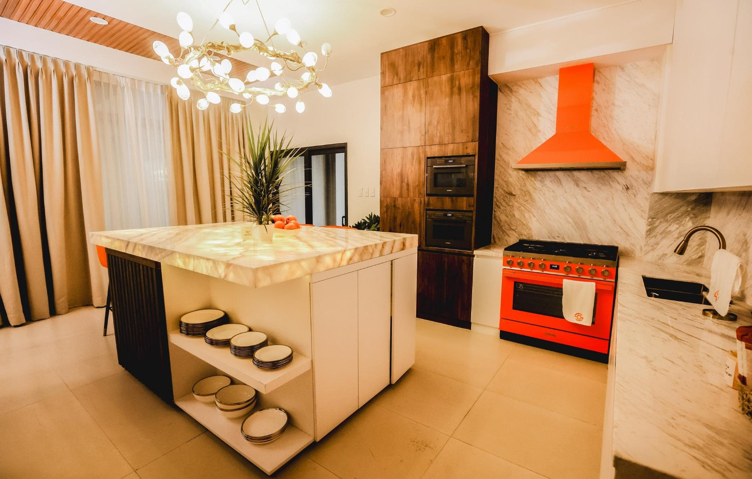 A modern kitchen with a bold  orange stove and a stylish white island, inviting warmth and creativity in cooking.