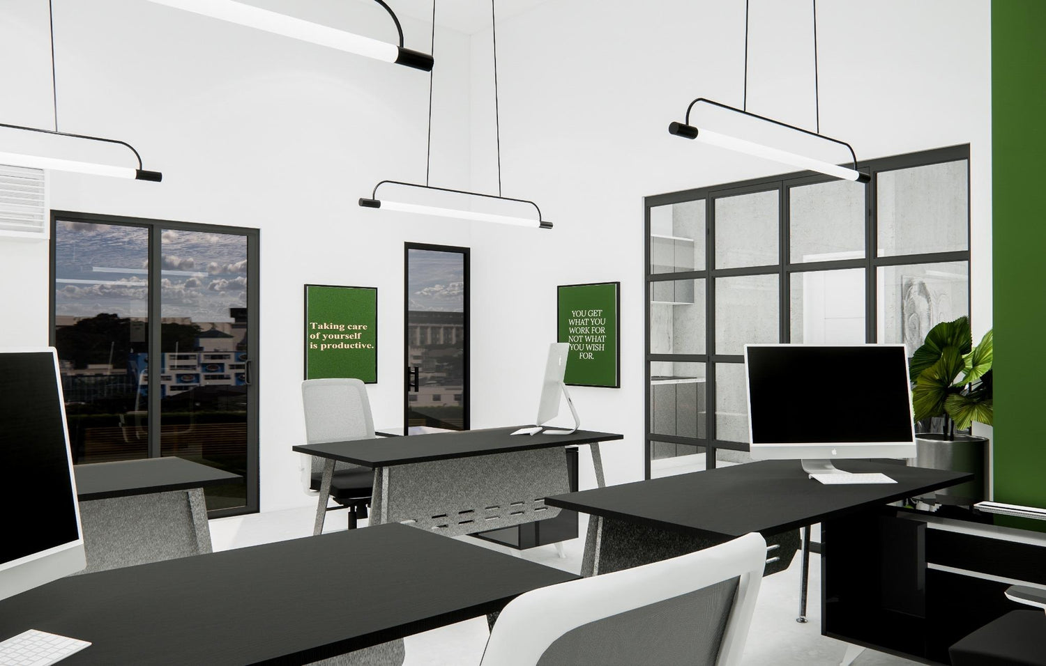Modern office interior with computers on desks, pendant lights, and a green framed artwork.