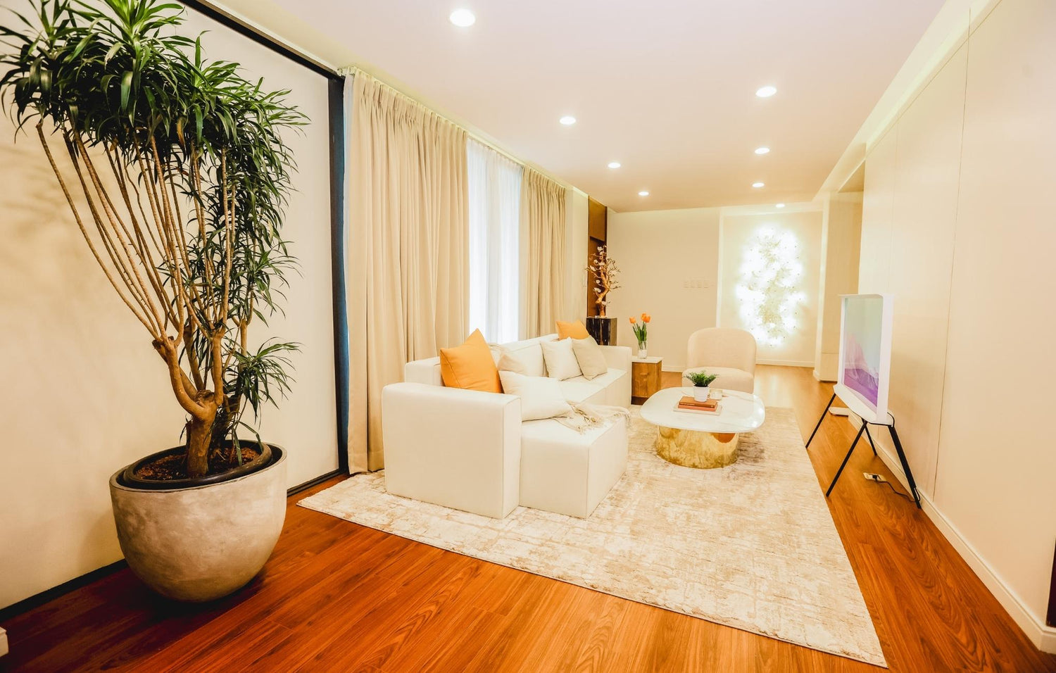  Modern living room showcasing a white couch, a sleek coffee table, and a decorative plant for a welcoming atmosphere.