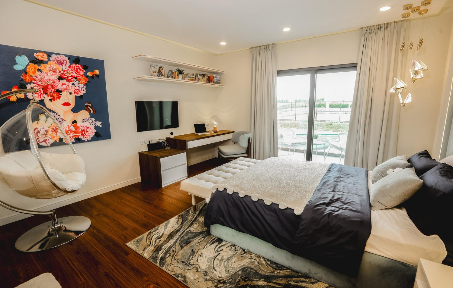 A cozy bedroom featuring a bed, a chair, and a colorful painting on the wall.