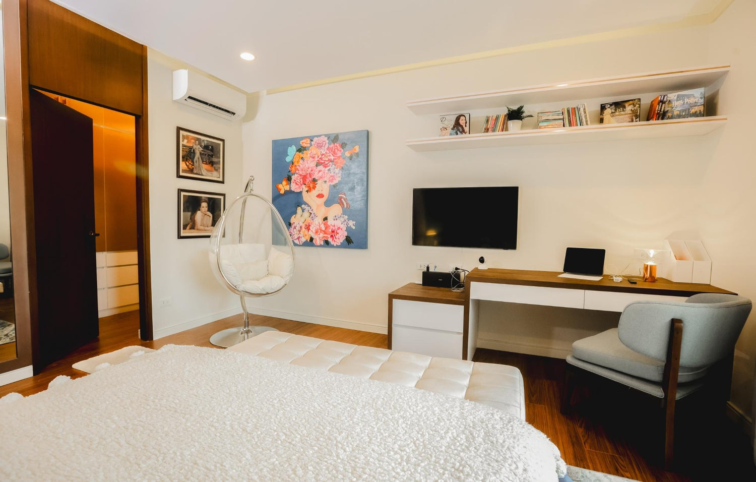 A cozy bedroom featuring a bed, a chair, and a colorful painting on the wall.