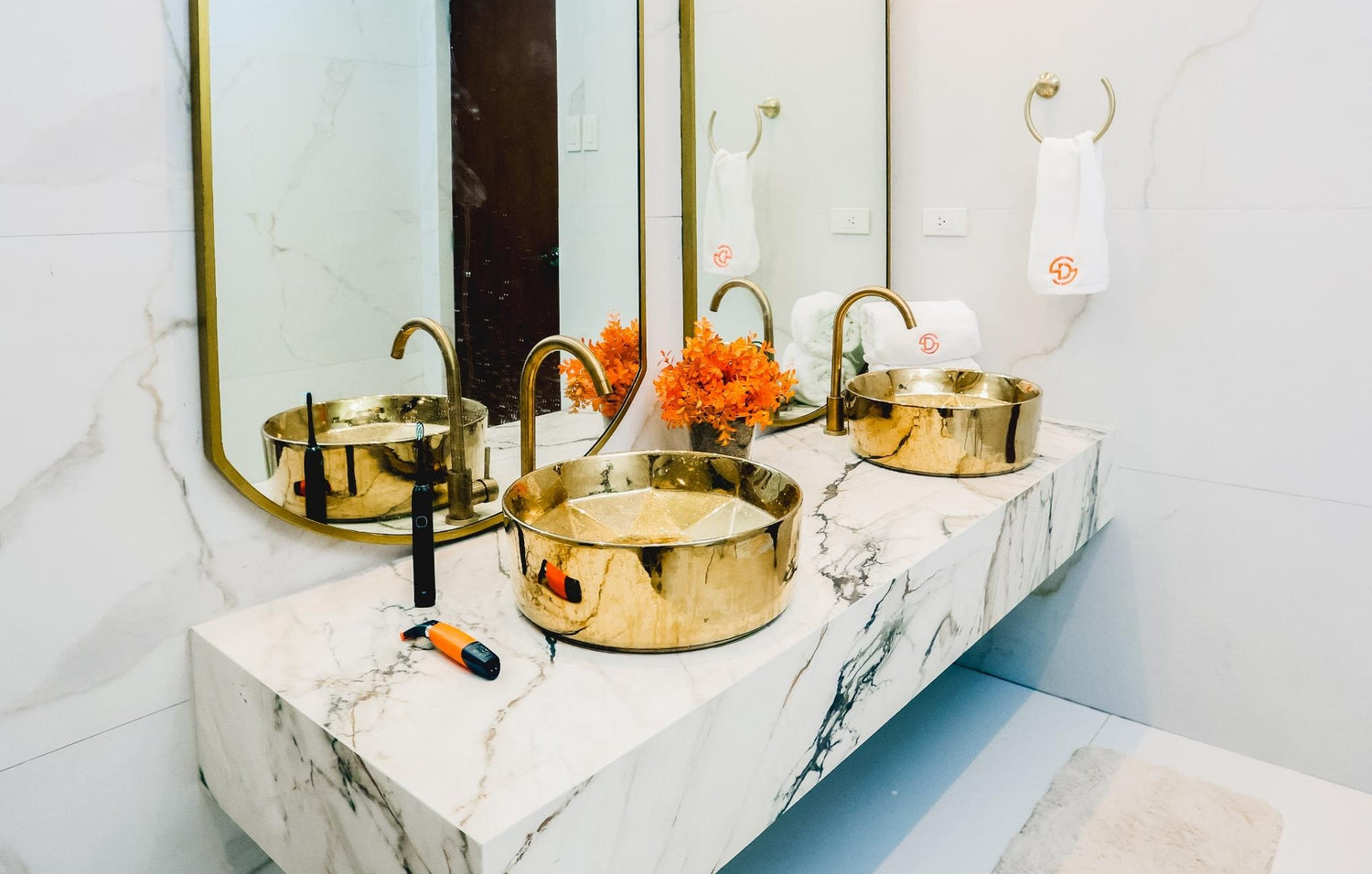  Elegant bathroom featuring two gold sinks and a stylish mirror, creating a luxurious and inviting atmosphere.
