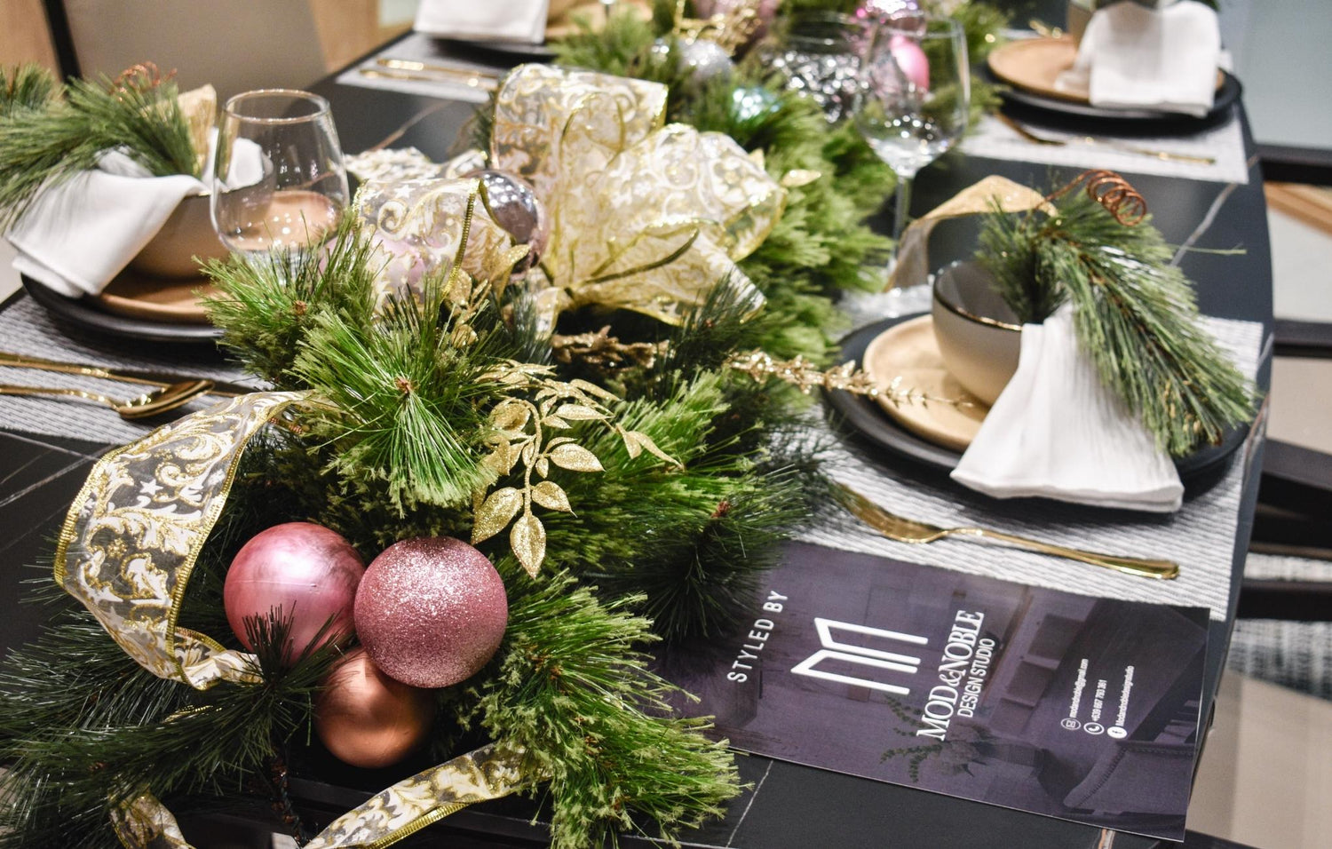 A beautifully arranged table setting adorned with festive Christmas decorations and colorful ornaments.