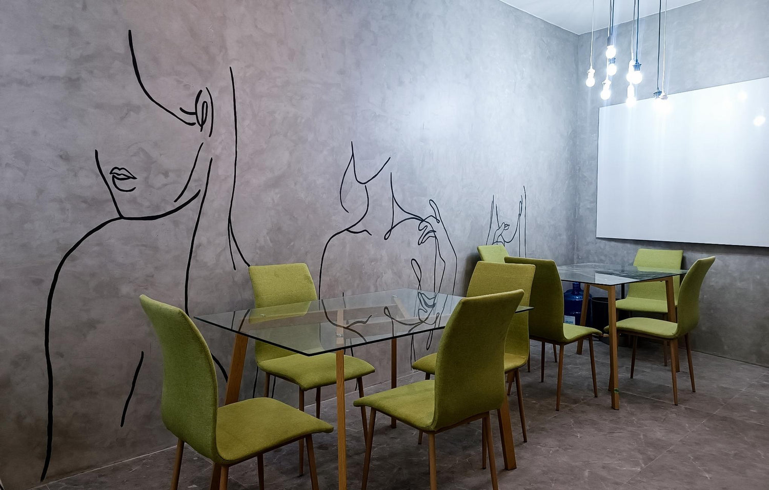  A cozy room featuring a table and chairs, with a wall adorned by a drawing of a woman.
