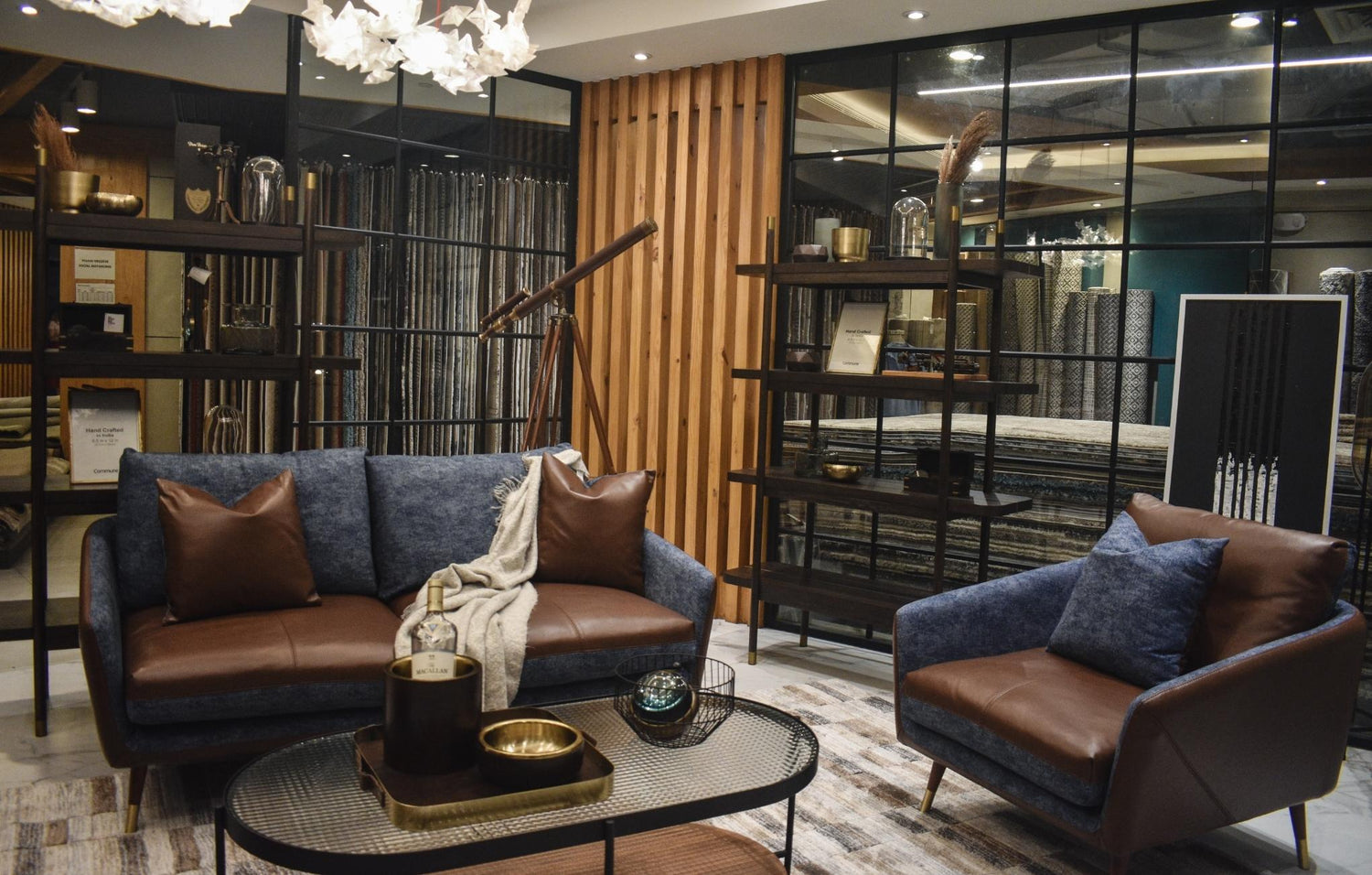 Elegant living room with blue and brown furniture, wooden accent wall, and stylish decor.