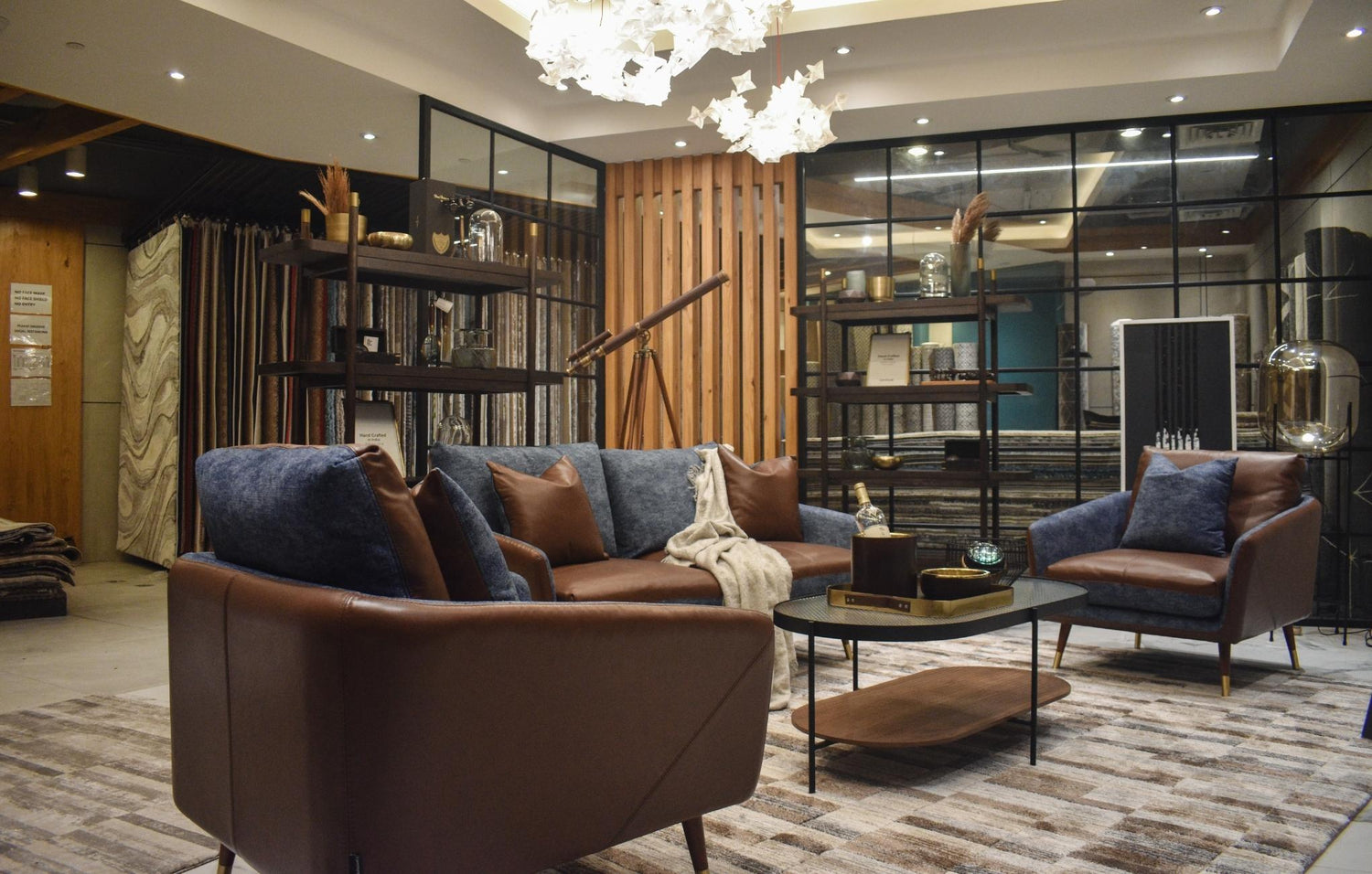 Modern living room with brown sofa, armchairs, coffee table, and chic decor.