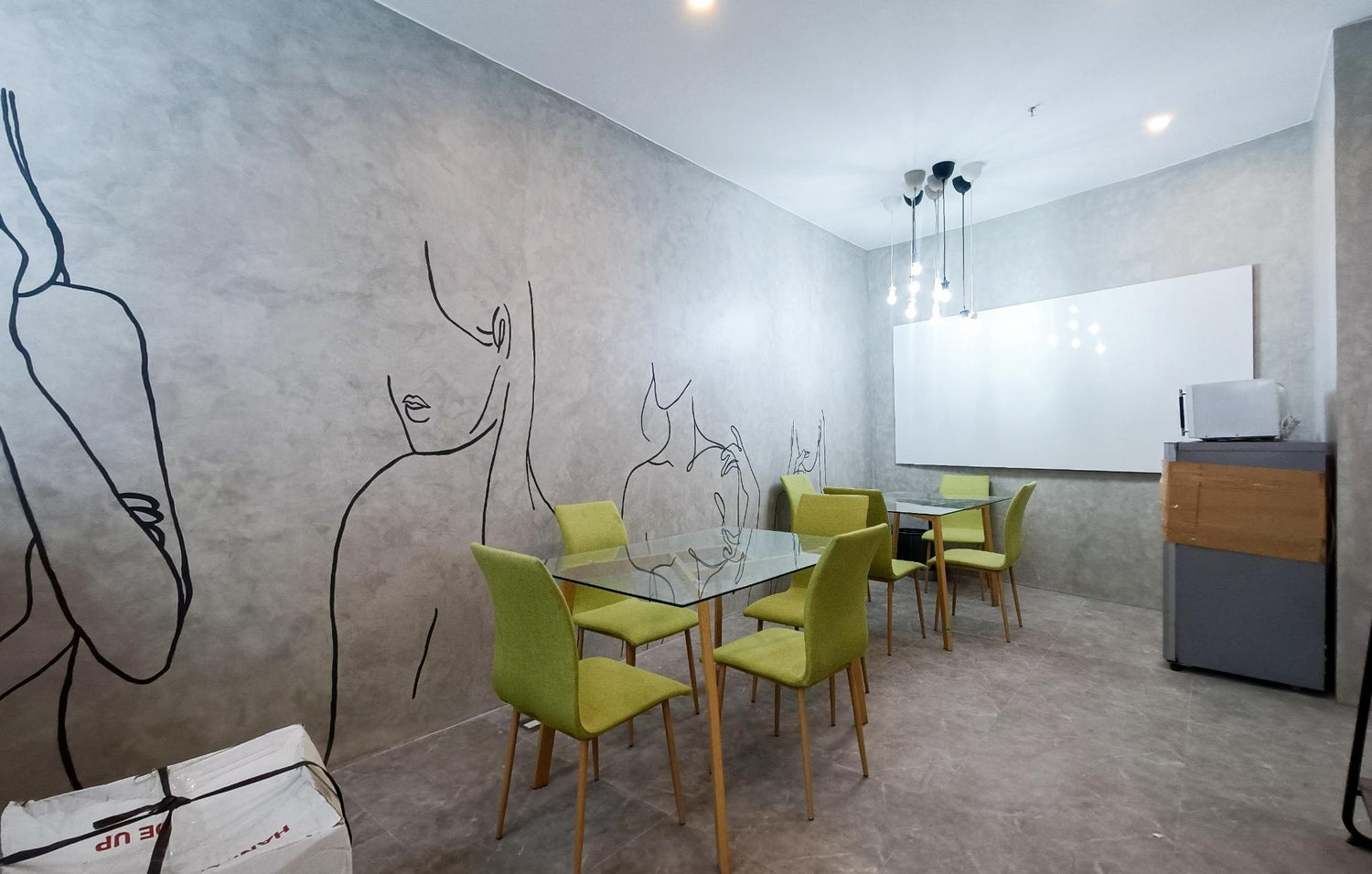  A cozy room featuring a table and chairs, with a wall adorned by a drawing of a woman.
