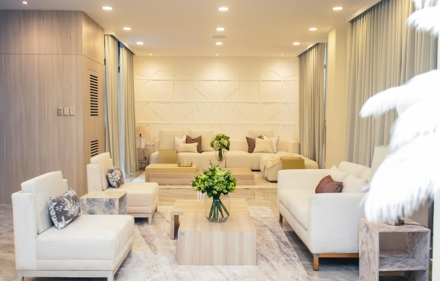  A modern living room showcasing elegant white furniture and a generous table, ideal for family time and entertaining.