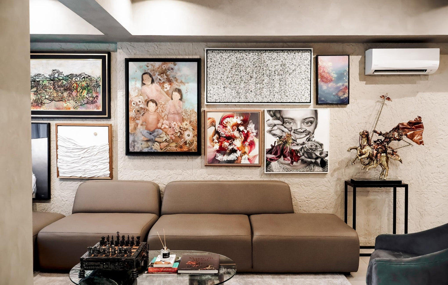 Cozy living room featuring a couch, coffee table, and colorful paintings adorning the walls.