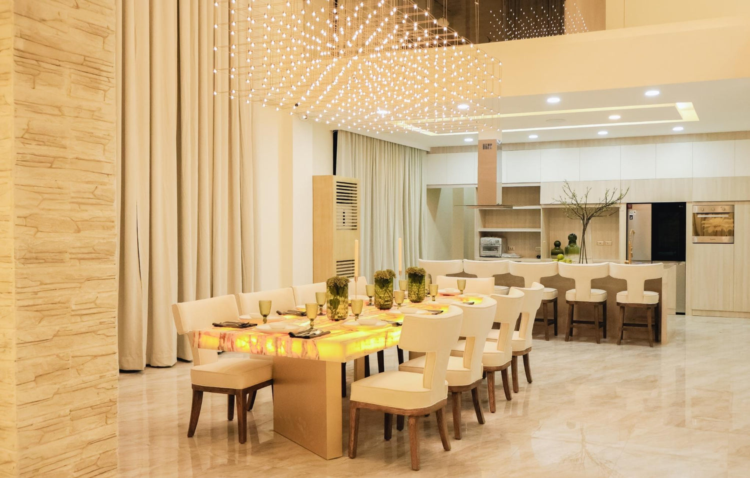 A bright living room featuring white furniture and a spacious table, creating a cozy and inviting atmosphere.

