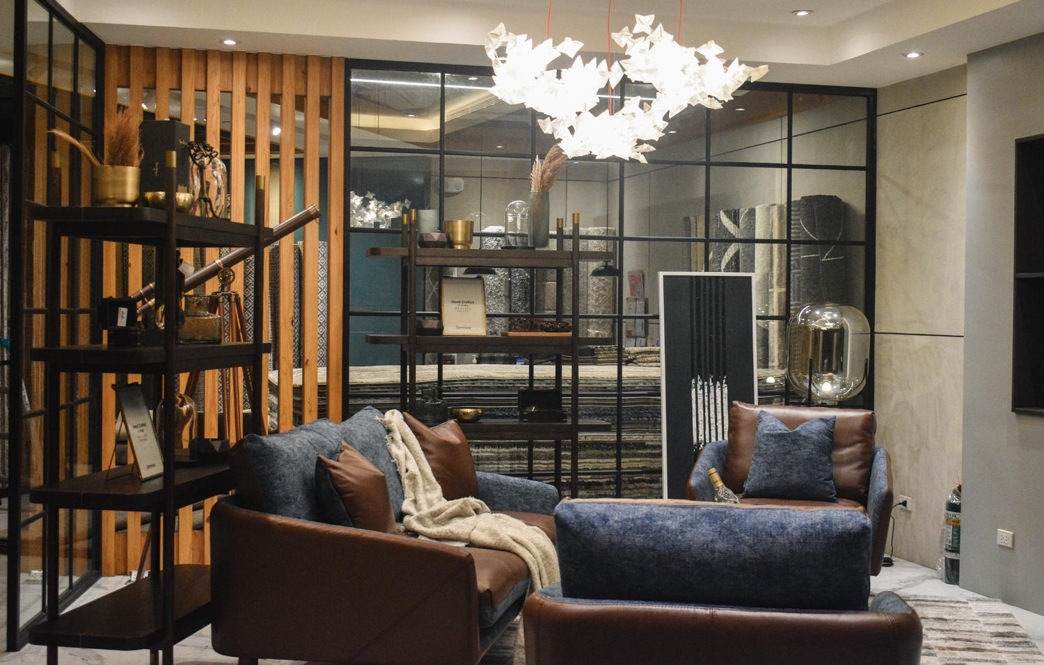 Elegant living room with modern furniture, decorative shelving, and artistic light fixture.