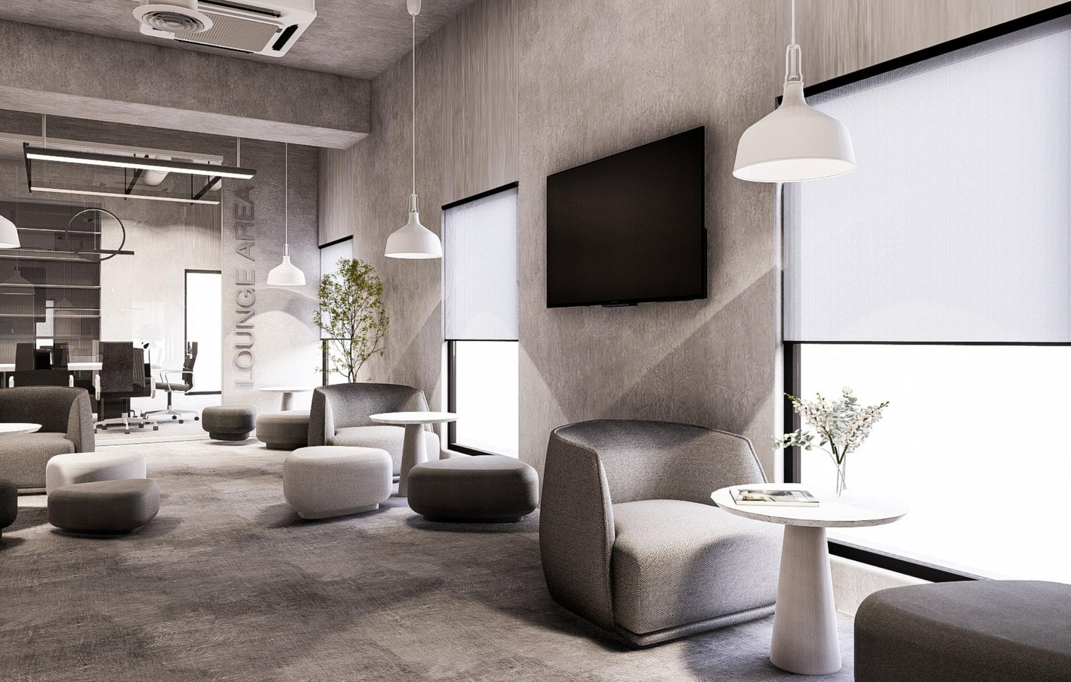 Modern office lounge area with gray sofas, pendant lights, and large windows.