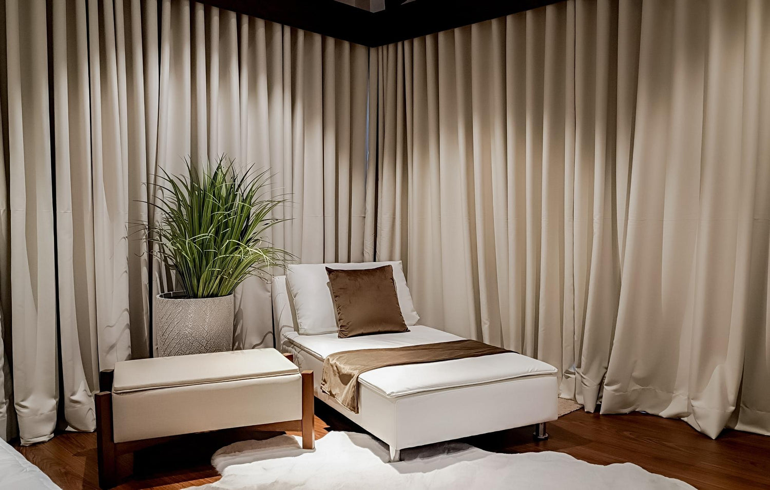 A cozy room featuring a white chair beside a vibrant green plant, creating a fresh and inviting atmosphere.