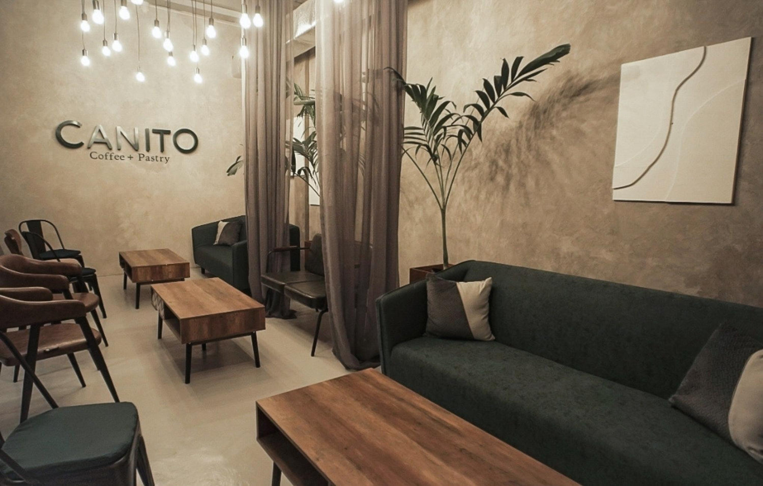 Cozy cafe interior with wooden furniture, pendant lights, and a sign "CANITO Coffee & Pastry".