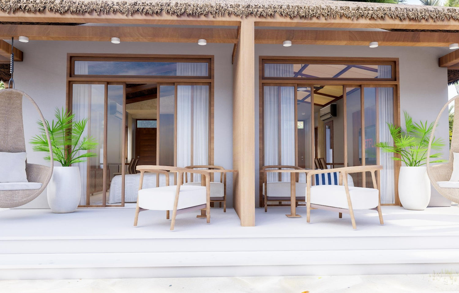 Beachfront patio with chairs, tables, and large planters outside a tropical villa.