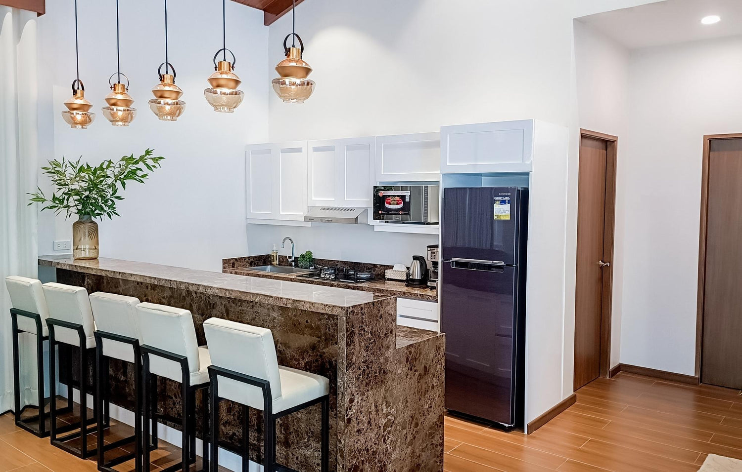 A spacious kitchen that includes a bar with stools, designed for casual dining and friendly conversations.
