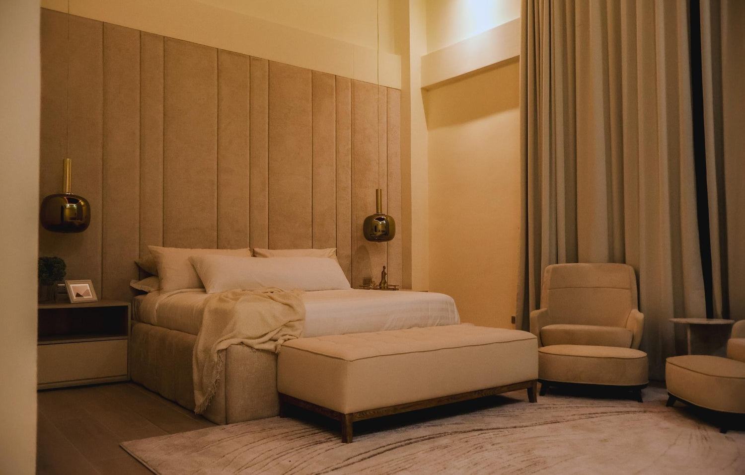 Cozy bedroom featuring a comfortable bed, a stylish chair, and a matching ottoman for relaxation.
