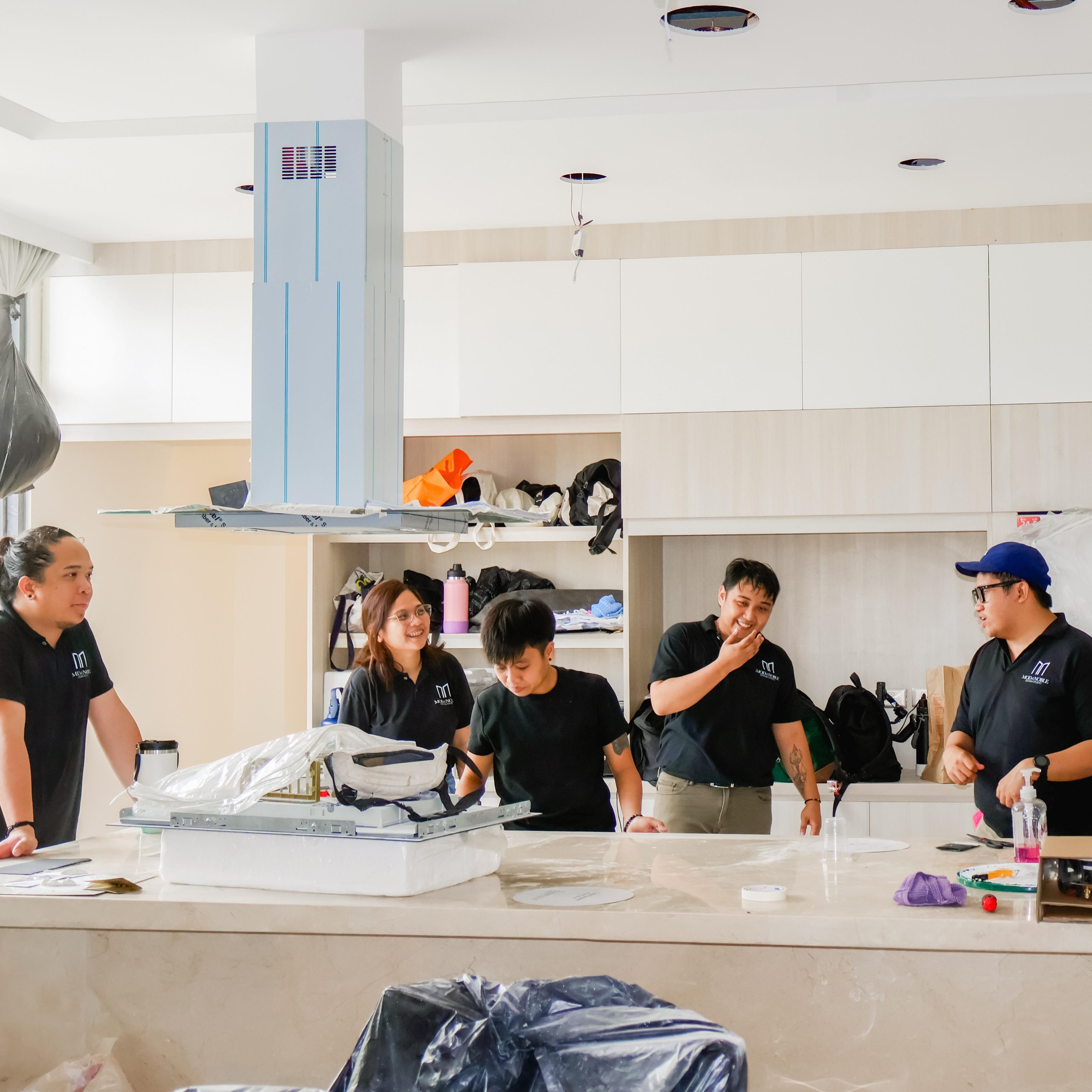 Mod and Noble Team, engages and working together in a kitchen, centered around a stove.