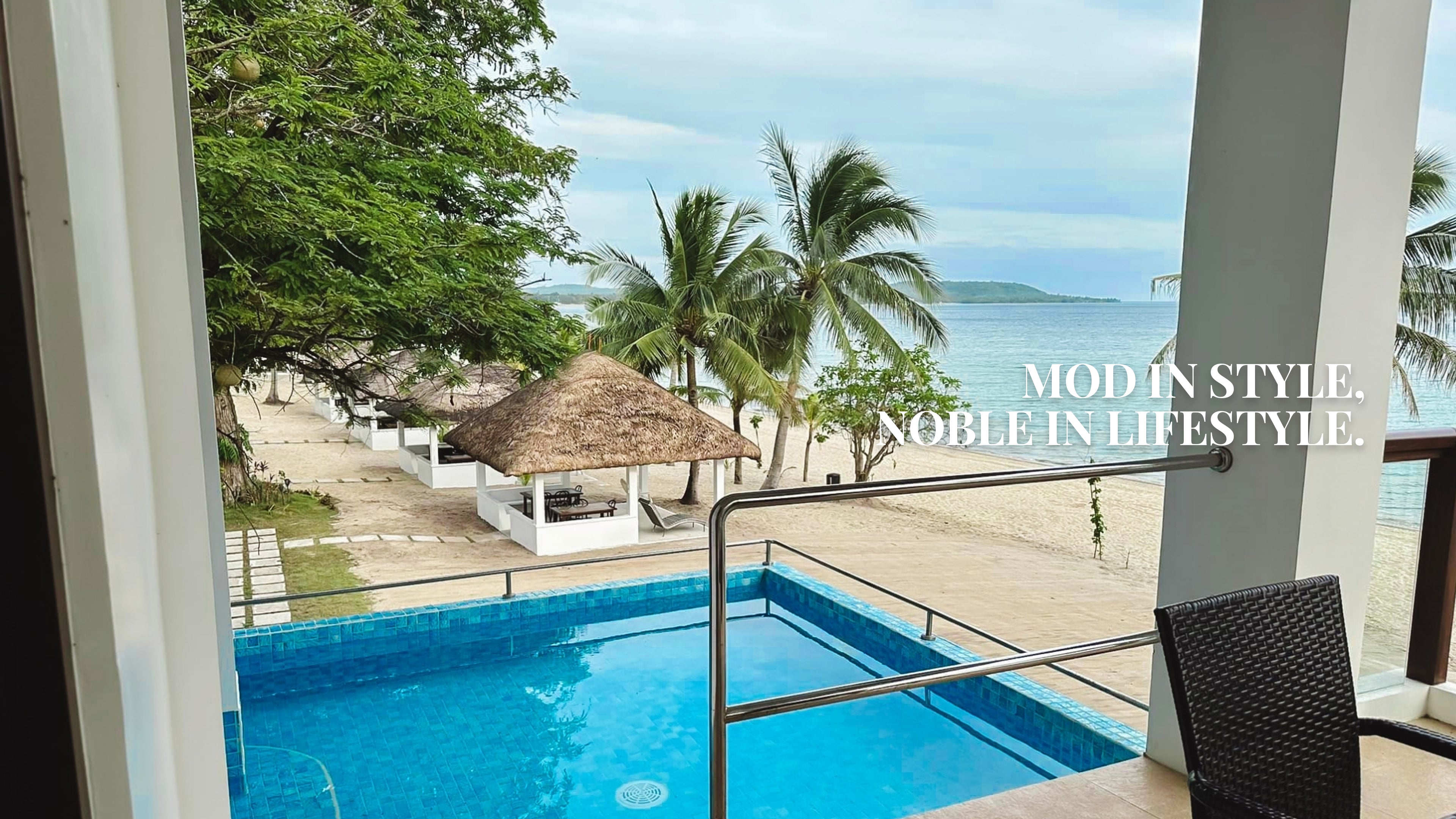 Beachfront villa view with private pool, palm trees, and ocean landscape by Mod and Noble Design Studio